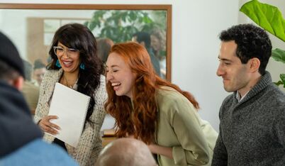 Image of a team conference. A girl is laughing.