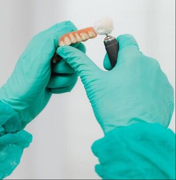 Picture of dental technician polishing dentures