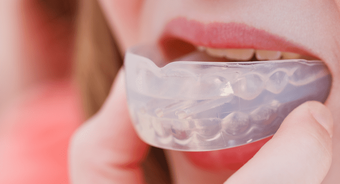 Picture of a woman putting a mouth guard in