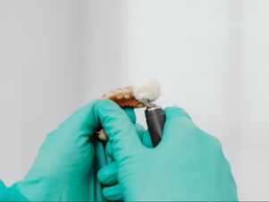 Picture of a dental technician polishing dentures