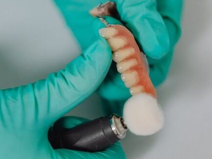 Picture of a dental technician buffing dentures