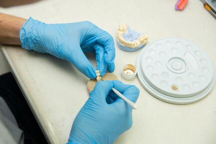 Picture of a dental technician painting teeth