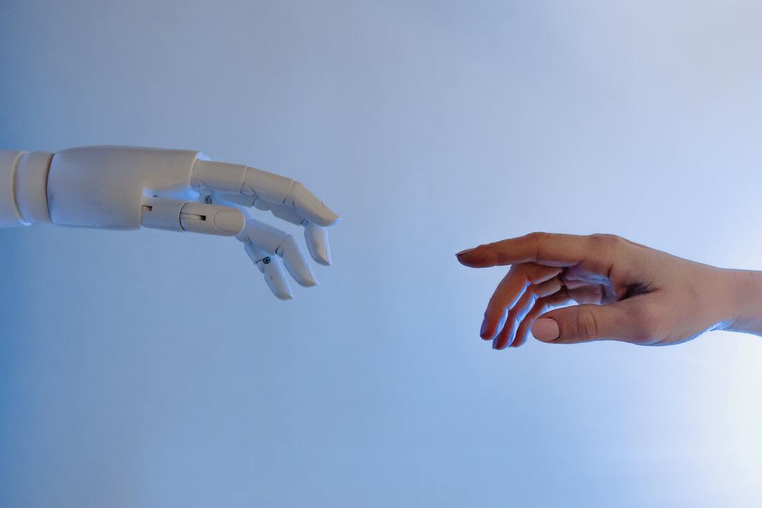 Picture of a robot hand and human hand reaching to each other